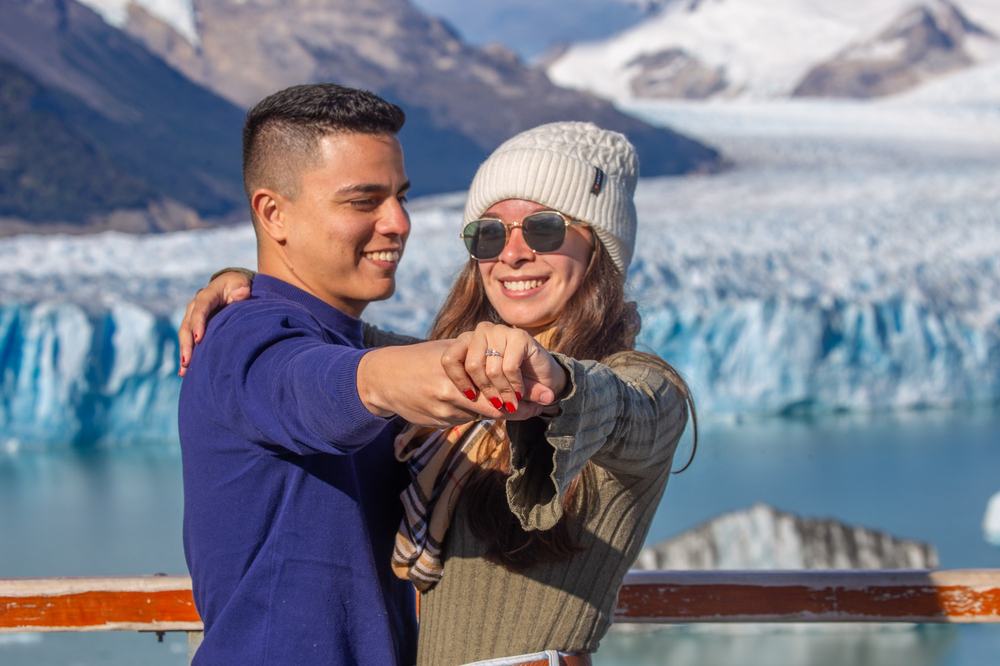 Una pareja muestra el anillo de compromiso frente al glaciar Perito Moreno