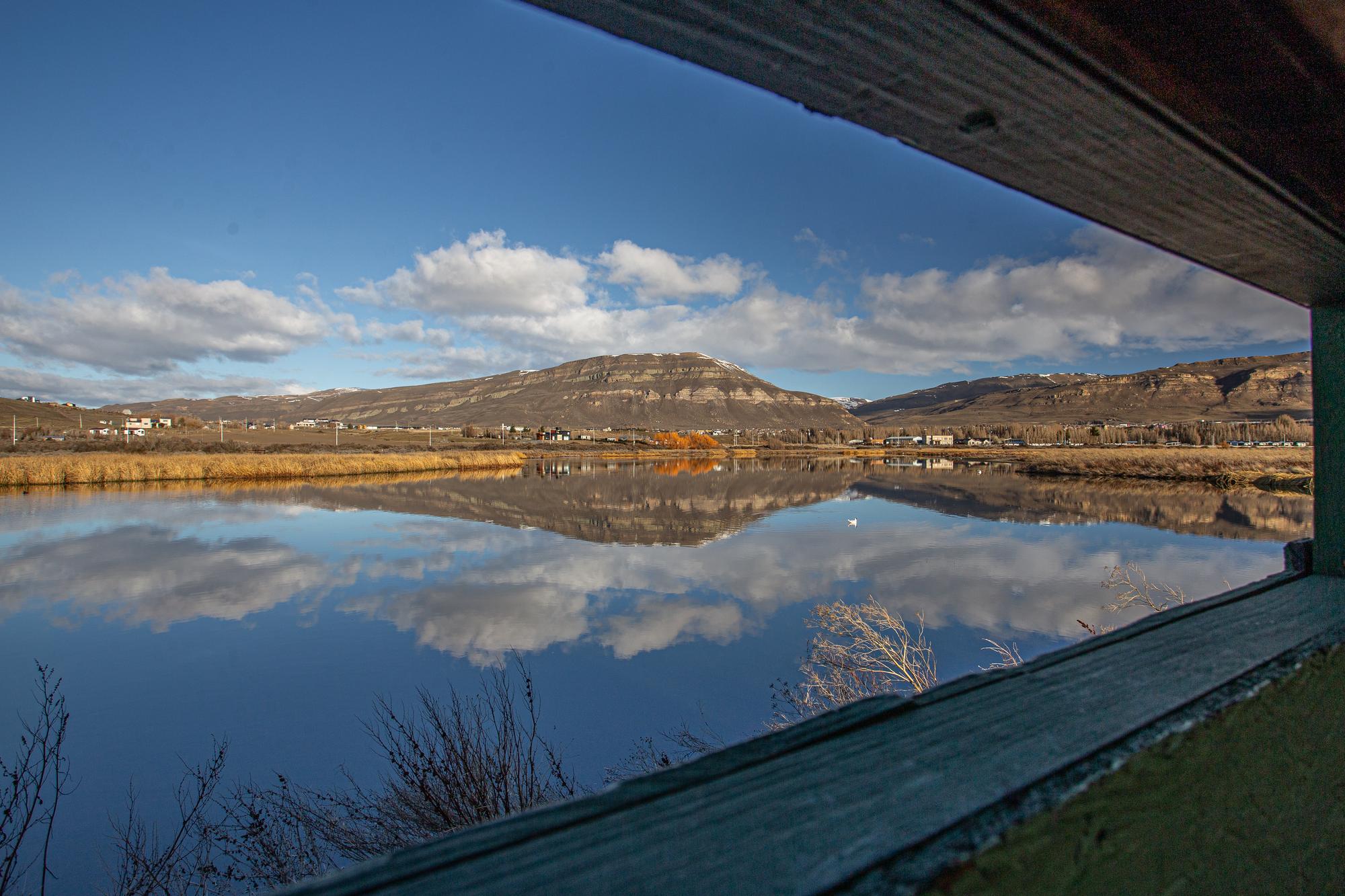 La Laguna Nimez y el cerro Calafate reflejados, vistos desde la ventana del observatorio de aves